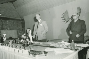 Uudenmaan piirin vuosikokous Espoon Vanhakartanossa vuonna 1958. Piirin puheenjohtaja S. O. Lindgren johtaa kokousta nuija kädessään. Suomen Metsästysmuseo. 